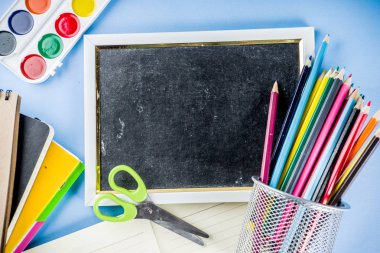 Geri okul ile arka plan için dershanede - boyalar, kalem, defter, kitap, makas, tebeşir, işaretleri, kopya alanı üzerinde mavi arka plan için aksesuarlar