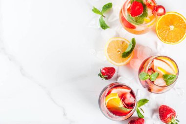 Taze meyveler, çilek ve nane ile soğuk beyaz, pembe ve kırmızı sangria kokteyller.