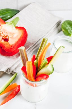 Yaz sağlıklı snack meze, çeşitli renkli taze sebze (kereviz, ravent, biber, salatalık ve havuç) yoğurt sos daldırma, beyaz mermer arka plan kopya alanı ile sopa
