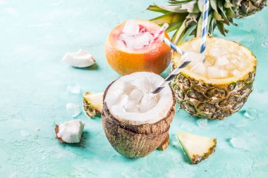 Yaz tatili için kavramı, çeşitli tropikal kokteyller veya meyve suları ananas, greyfurt ve Hindistan cevizi ile buz, açık mavi beton renkli kopya alanı ayarla