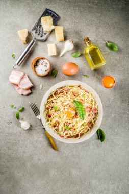 Geleneksel İtalyan Makarna, spagetti carbonara pastırma, krem sos, parmesan peyniri, yumurta sarısı ve taze fesleğen yaprakları gri taş arka plan kopya alanı