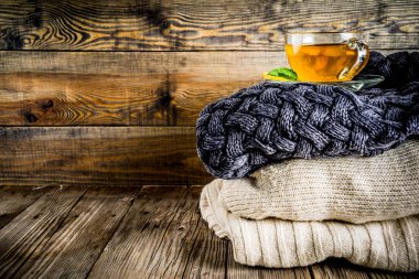 Sonbahar konfor ve sıcak kavramı. Çay cam bardağı limon, nane ve baharatlar, sıcak battaniye ile eski rustik ahşap arka plan üzerinde. Metin için yer kopyalayın