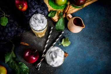 Baharatlı karamel Apple ya da elmalı turta iki yüzlü, elma, yaprak, karamel sos ve sıcak bir battaniye ile karanlık bir arka plan üzerine krem şanti ile organik sonbahar meyve kokteyli. Metin için yer kopyalayın