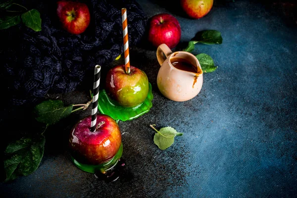 Geleneksel sonbahar incelik, karamelli elma sır. Karanlık bir arka plan üzerinde elma, yaprak, karamel sos ve sıcak bir battaniye ile. Metin için yer kopyalayın