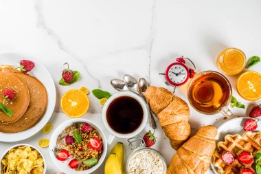 Sağlıklı kahvaltı yemek kavramı, çeşitli sabah gıda - gözleme, gözleme, kruvasan yulaf ezmesi sandviç ve granola yoğurt, meyve, meyveler, kahve, çay, portakal suyu, beyaz arka plan