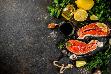 Çiğ Somon Balık biftek ile limon, otlar, zeytin yağı, ızgara, kayrak kesme tahtası, karanlık paslı arka plan kopya alanı için hazır