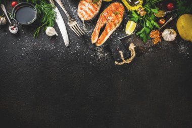 Izgara Somon Balık biftek malzemeler limon, otlar, zeytin yağı, kayrak kesme tahtası, karanlık paslı arka plan kopya alanı ile