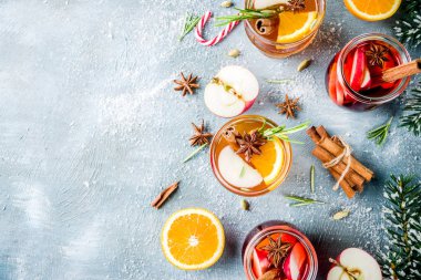 Geleneksel kış içecekler, beyaz ve kırmızı mulled şarap kokteyl ile beyaz ve kırmızı şarap, baharat, elma, portakal. Üzerinde mavi masa lambası,