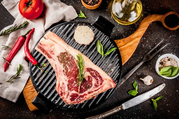 Ham sığır eti striplon kaburga eti baharat, ızgara tava ve otlar, koyu arka plan üstten görünüm, kopya alanı ile mermer
