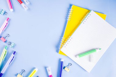 Geri okul ile arka plan için parlak aksesuarları malzemeleri okul ve çalışma - kalem, kalem, işaretçileri, kalemler, cetveller, ataç, sopa, dizüstü bilgisayarlar için. Açık mavi arka planı üzerinde üst görüntülemek, metin için özgür kopya yer