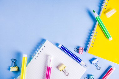Geri okul ile arka plan için parlak aksesuarları malzemeleri okul ve çalışma - kalem, kalem, işaretçileri, kalemler, cetveller, ataç, sopa, dizüstü bilgisayarlar için. Açık mavi arka planı üzerinde üst görüntülemek, metin için özgür kopya yer