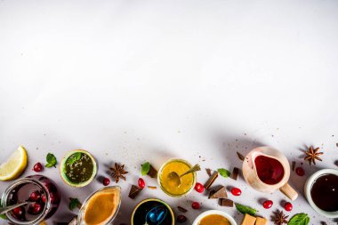 Çeşitli tatlı soslar, soslar ve şuruplar - limon, portakal, karamel, çikolata, kızılcık, kiraz, yaban mersini, hafif bir beton zemin üzerine metin için görünümü Kopyala yer top