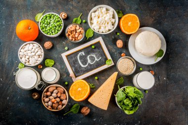 Sağlıklı gıda kavramı. Kalsiyum - süt ve vegan Ca ürünleri, koyu mavi arka plan kopya alanı üstten görünüm zengin besin kümesi