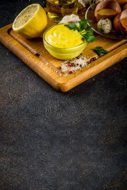 Ev yapımı mayonez sos malzemeler - limon, yumurta, zeytinyağı, baharat ve otlar, siyah beton arka plan kopya alanı ile