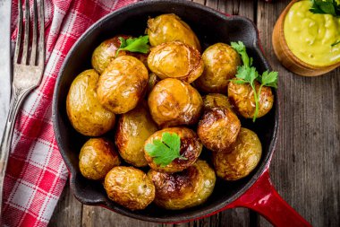 Fırında kızartma tavası bütün genç patates, ev yapımı Vejetaryen yiyecekler, eski ahşap rustik masa, sosu, yukarıdaki alanı Kopyala