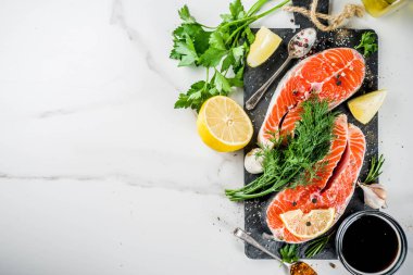Biftek ile limon, otlar, zeytin yağı, ızgara, kayrak kesme tahtası, beyaz mermer zemin kopya alanı yukarıdaki için hazır çiğ Somon Balık