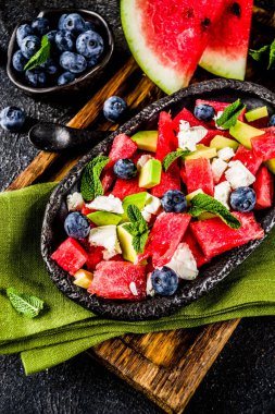 Yaz gıda kavramı, beyaz peynir, yaban mersini, avokado ve nane, karanlık paslı arka plan kopya alanı ile taze soğuk karpuz salatası
