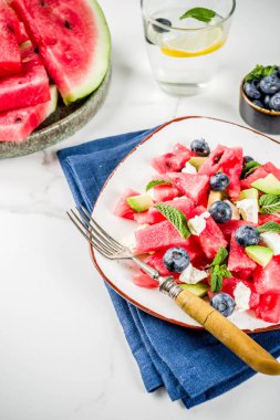 Yaz gıda kavramı, beyaz peynir, yaban mersini, avokado ve nane, beyaz mermer zemin kopya alanı ile taze soğuk karpuz salatası