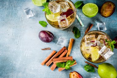 Yaz ferahlık içecek buzlu. Tarçın ve Erik limonata kokteyl ile taze limon ve nane, mavi arka plan boşluk kopyalama