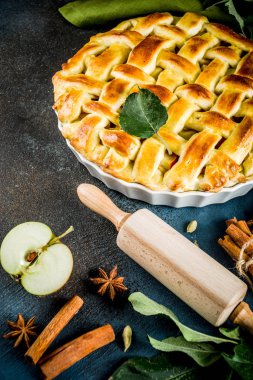 Geleneksel sonbahar pişirme, ev yapımı elma pasta ile tarçın, koyu mavi arka plan ile çalışırken rulo, pudra şekeri, taze elma, baharatlar, alan üst görünüm Kopyala