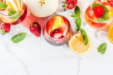 Taze meyveler, çilek ve nane ile soğuk beyaz, pembe ve kırmızı sangria kokteyller.