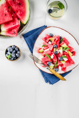 Yaz gıda kavramı, beyaz peynir, yaban mersini, avokado ve nane, beyaz mermer zemin kopya alanı ile taze soğuk karpuz salatası