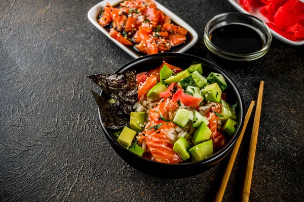 アジア系のトレンディな食べ物寿司キュウリ サーモン アボカド 白と黒胡麻とボウルを突く — ストック写真