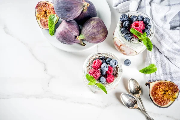 Sağlıklı detoks kahvaltı meze - yoğurt güler yüzlü veya milkshake incir, yaban mersini, ahududu chia tohumu, beyaz mermer zemin, kopya alanı ile
