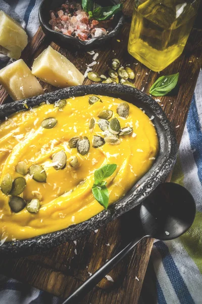 Balkabağı parmesan çorbası kabak çekirdeği, fesleğen yaprakları ve parmesan peyniri wit, mavi arka plan kopya alanı yukarıdan ışık