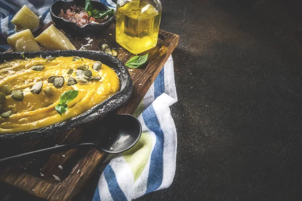 Balkabağı parmesan çorbası kabak çekirdeği, fesleğen yaprakları ve parmesan peyniri wit, mavi arka plan kopya alanı yukarıdan ışık