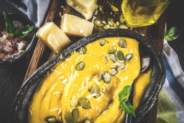 Balkabağı parmesan çorbası kabak çekirdeği, fesleğen yaprakları ve parmesan peyniri wit, mavi arka plan kopya alanı yukarıdan ışık