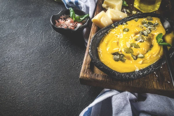 Balkabağı parmesan çorbası kabak çekirdeği, fesleğen yaprakları ve parmesan peyniri wit, mavi arka plan kopya alanı yukarıdan ışık