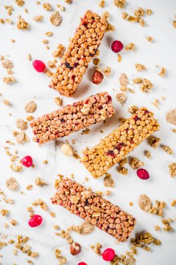 Çok tahıl granola müsli bar. Sağlıklı yiyecek, kurutulmuş meyveler, fındık, tahıl ve bal ile diyet snack. Bir beyaz mermer zemin, üstten görünüm Kopyala yer metin için.