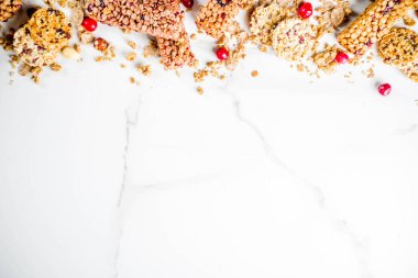 Çok tahıl granola müsli bar. Sağlıklı yiyecek, kurutulmuş meyveler, fındık, tahıl ve bal ile diyet snack. Bir beyaz mermer zemin, üstten görünüm Kopyala yer metin için.