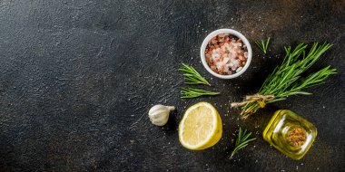 Gıda maddeleri arka plan yemek. Baharat, sarımsak, otlar, zeytin yağı. paslı siyah taş tablo. Kopya alanı afiş yukarıda