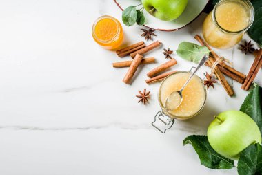 Ev yapımı elma reçel veya sosu, yeşil elma ve baharatlar, beyaz mermer zemin kopya alanı ile