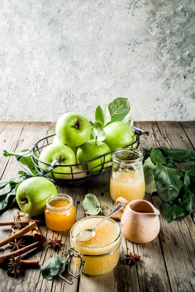 Homemade apple jam or sauce, with green apples and spices, wooden rustic background copy space