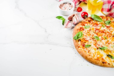Ev yapımı dilimlenmiş peynirli klasik İtalyan pizza malzemeleri ve zeytinyağı, beyaz mermer zemin kopya alanı üstten görünüm