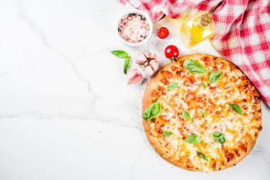 Ev yapımı dilimlenmiş peynirli klasik İtalyan pizza malzemeleri ve zeytinyağı, beyaz mermer zemin kopya alanı üstten görünüm
