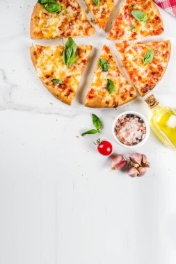 Ev yapımı dilimlenmiş peynirli klasik İtalyan pizza malzemeleri ve zeytinyağı, beyaz mermer zemin kopya alanı üstten görünüm