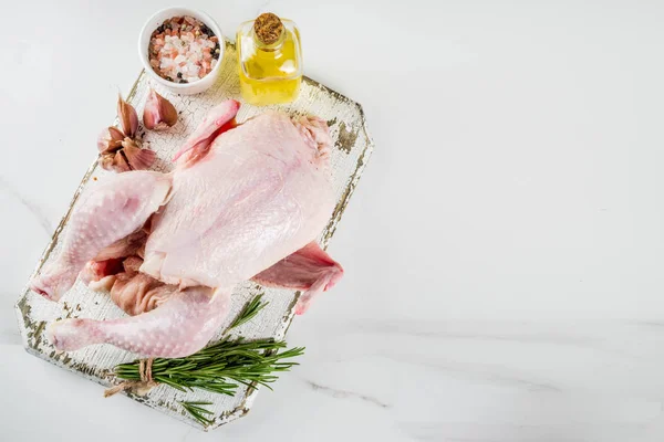 Raw whole chicken ready for cooking white marble background copy space