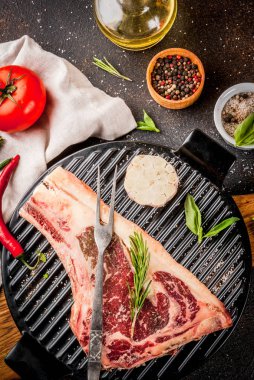 Ham sığır eti striplon kaburga eti baharat, ızgara tava ve otlar, koyu arka plan üstten görünüm, kopya alanı ile mermer