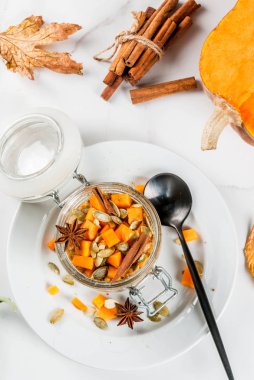 Sağlıklı vegan gıda. Diyet Kahvaltı veya aperatif. Kabak pasta gecede yulaf, kabak, yoğurt, tarçın, baharatlar. Bir bardak, bir beyaz mermer tablo. Alan üst görünüm Kopyala