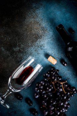 Cam ve üzüm ile kırmızı şarap şişesi, koyu arka plan kopya alanı üstten görünüm seçici odak