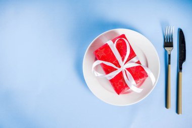 Noel kavramı, arka plan şenlikli ambalaj, açık mavi renkli kopya alanı yukarıdaki tabak, çatal, bıçak ve hediye kutusu ile yemek