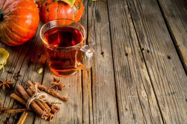 Baharatlı balkabağı çay, pumpkins, tarçın ve eski rustik ahşap arka plan üzerinde baharatlar ile Sonbahar sıcak içecek cam fincan alanı Kopyala