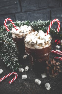 Naneli krema ve şeker kamışı tatlı Noel tatili için cam bardak sıcak çikolata, karanlık paslı arka plan kopya alanı tonda.