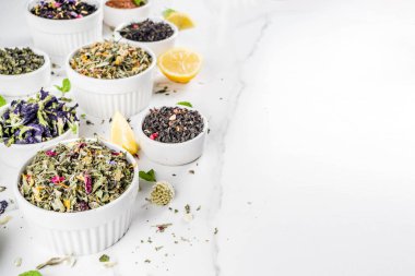 Çeşitli kuru çay - klasik siyah ve yeşil, çiçek, meyve, berry ve bitkisel çay karışımları, limon ve nane, ürün yelpazesine beyaz mermer zemin kopya alanı üst görüntüleme