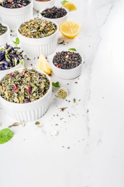 Çeşitli kuru çay - klasik siyah ve yeşil, çiçek, meyve, berry ve bitkisel çay karışımları, limon ve nane, ürün yelpazesine beyaz mermer zemin kopya alanı üst görüntüleme