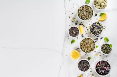 Çeşitli kuru çay - klasik siyah ve yeşil, çiçek, meyve, berry ve bitkisel çay karışımları, limon ve nane, ürün yelpazesine beyaz mermer zemin kopya alanı üst görüntüleme